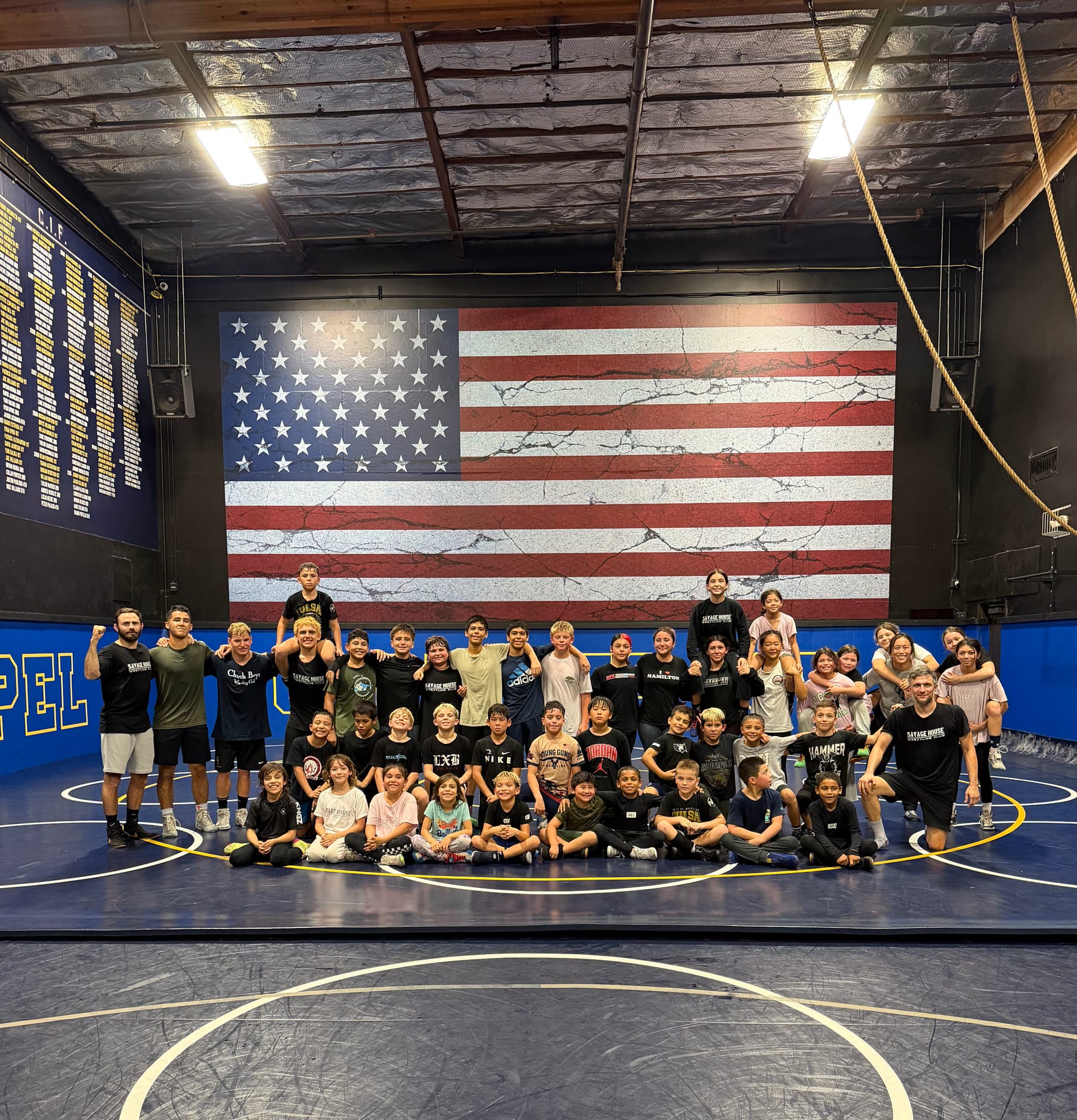 Savage OC wrestlers and coaches in the Calvary Chapel High School mat room